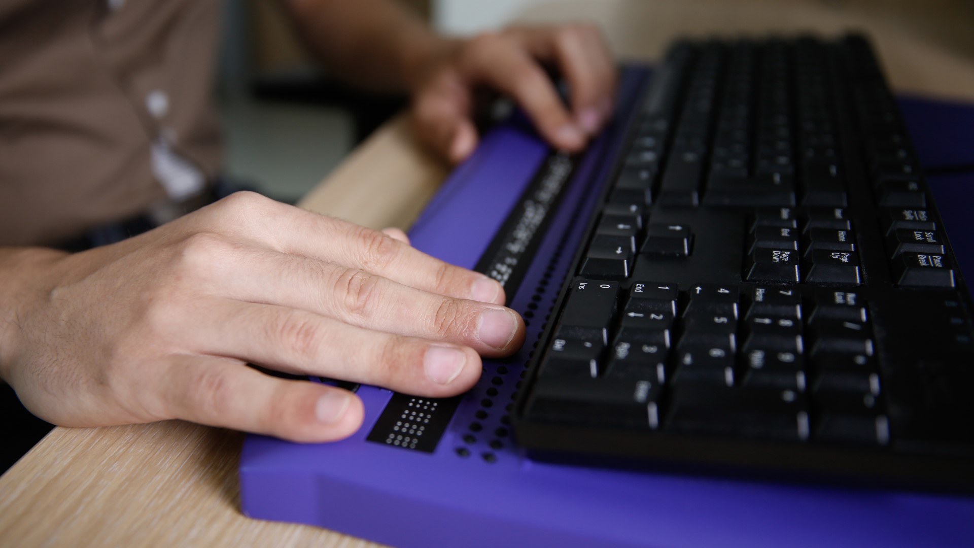 pessoa utilizando teclado de computador em braile